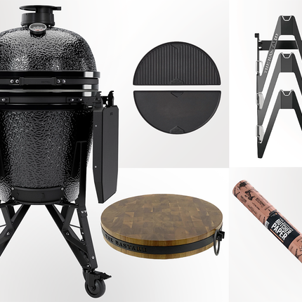 The Bastard kamado - Core complete Large gloss Graphite vooraanzicht met daarnaast de upgradebox bestaande uit Half moon cast iron Griddle, essential rack, butcher block en butcher paper