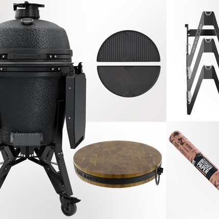 The Bastard - PRO kamado Large Desert Graphite - vooraanzicht met daarnaast de upgradebox bestaande uit Half moon cast iron Griddle, essential rack, butcher block en butcher paper